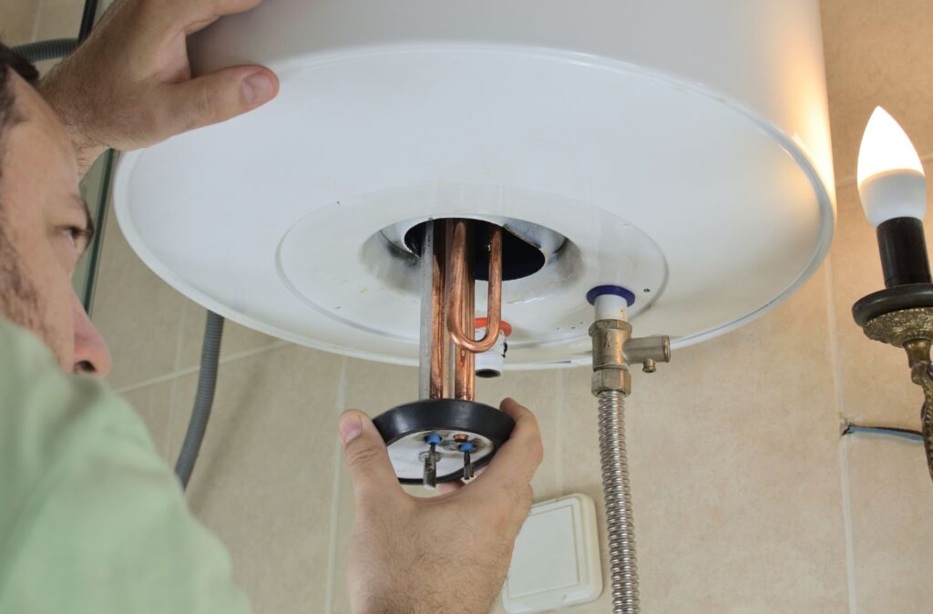 Sump Pump Services in Downingtown, PA 1 Hand working on water heater