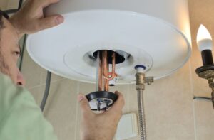 Hand working on water heater